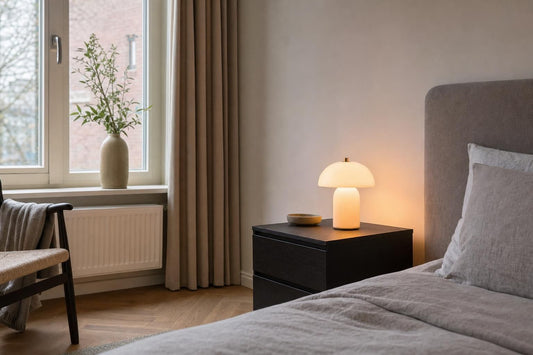 Nachtkastlampje op een nachtkast naast een bed in de slaapkamer