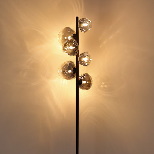 Zwarte metalen vloerlamp met rookglazen bollen en vertakte armen – sfeerbeeld