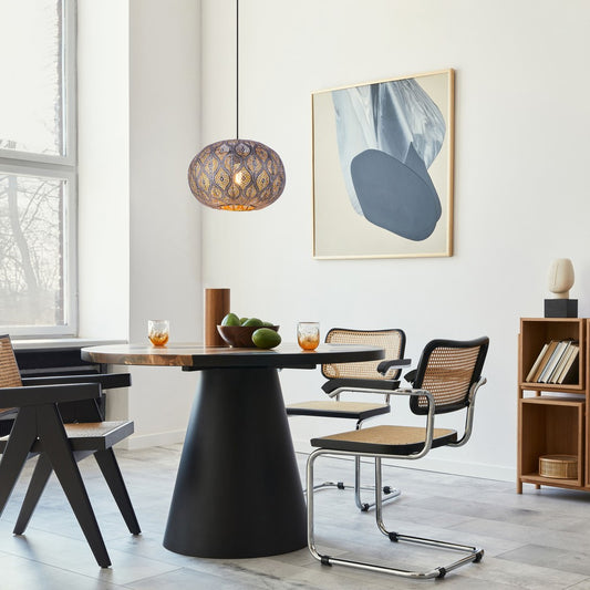 Zwarte metalen hanglamp met opengewerkt patroon en bolvormige kap – sfeerbeeld